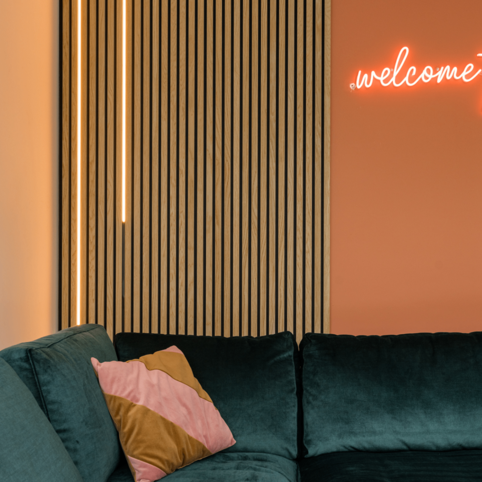 Naturel eiken akoestisch paneel met LED strip boven groene bank