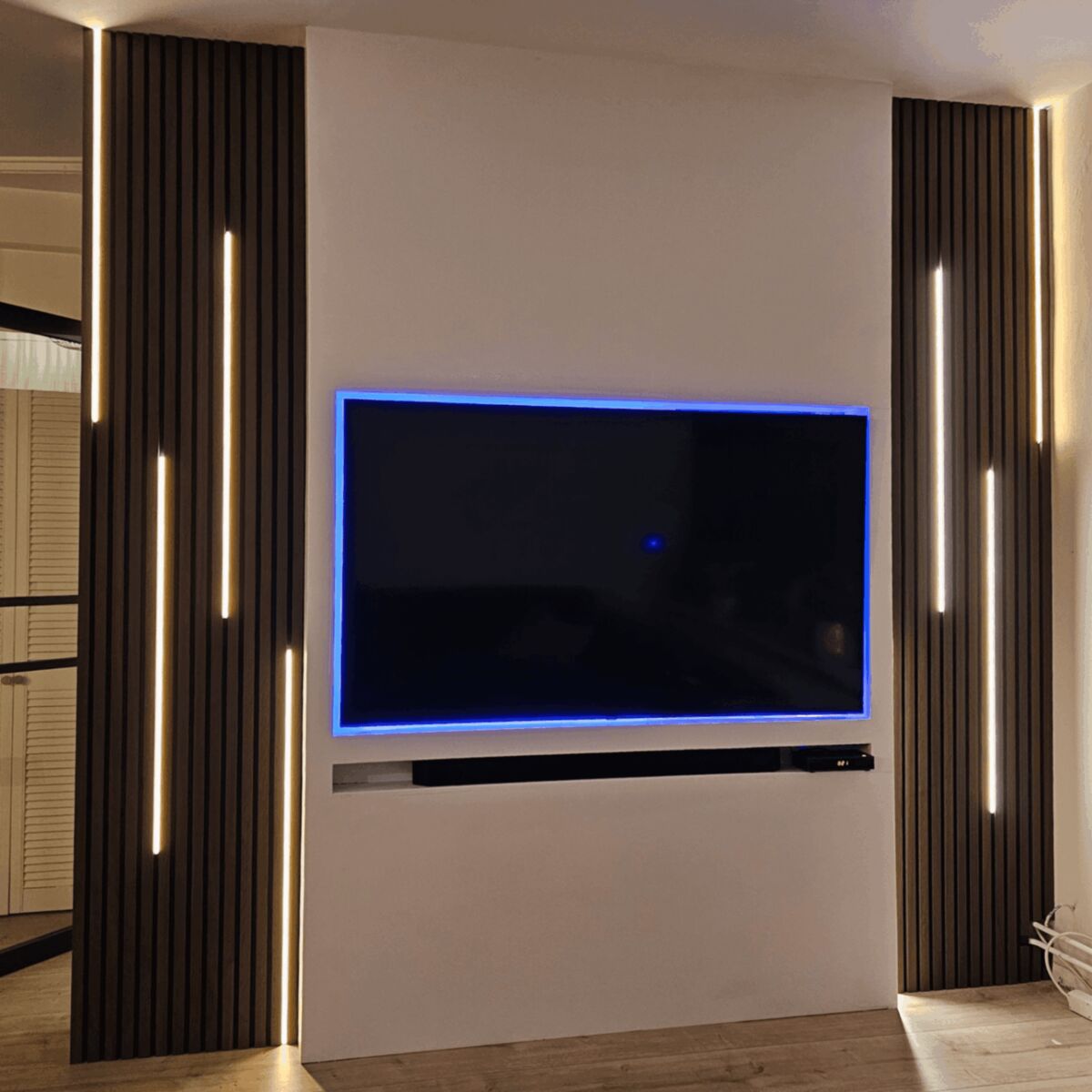 Akoestische panelen naast TV wand met LED verlichting