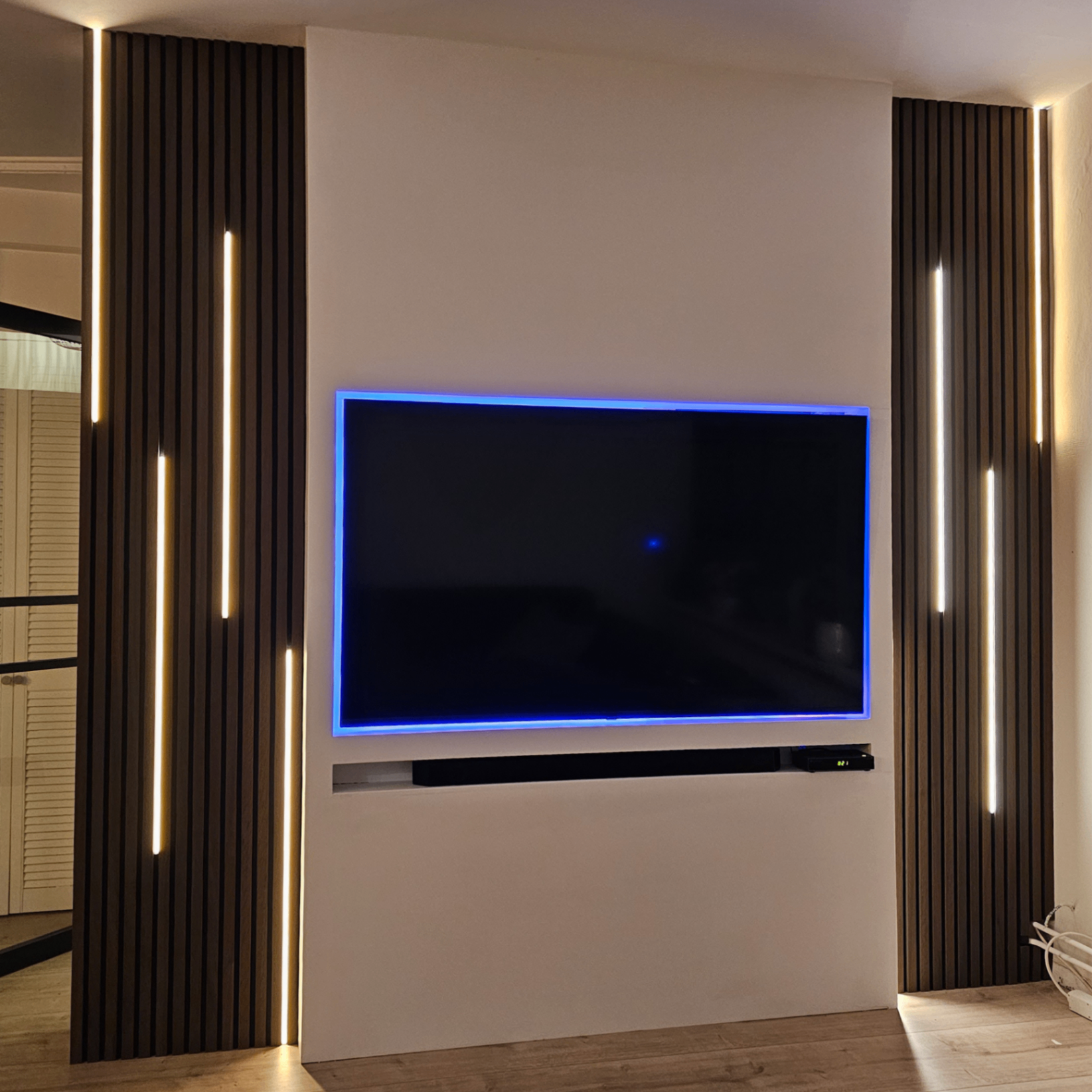 Akoestische panelen naast TV wand met LED verlichting